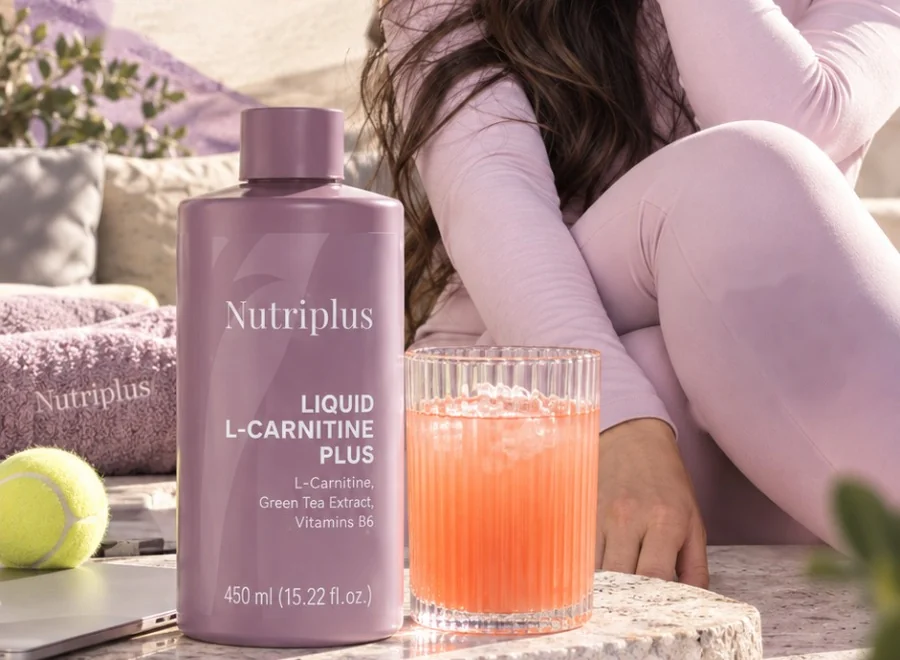 Nutriplus Liquid L-Carnitine Plus junto a un vaso de bebida, una pelota de tenis y una toalla Nutriplus