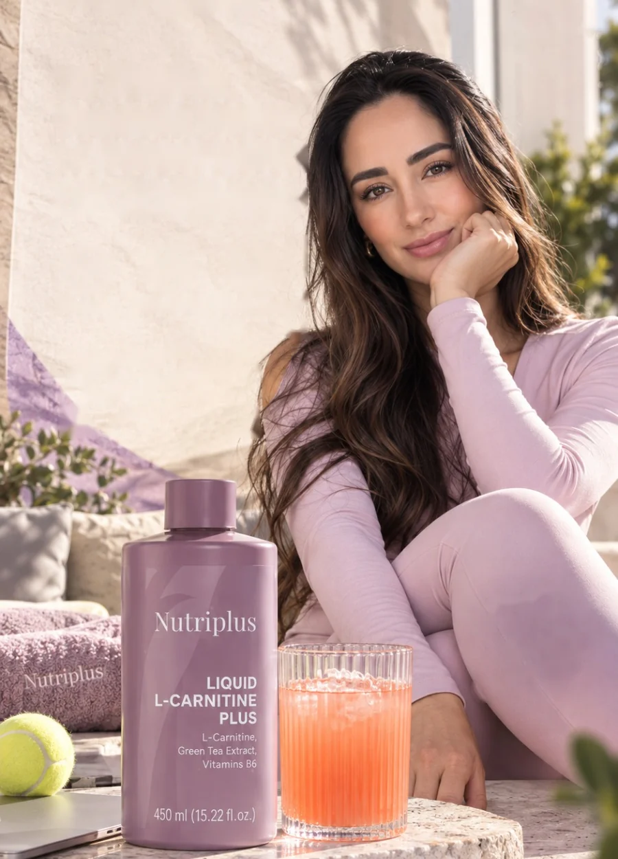 Eva Bicerra sonriendo junto a Nutriplus Liquid L-Carnitine Plus y un vaso de bebida fría